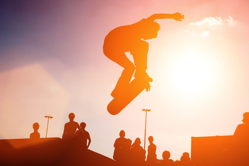 Jumping skateboarder against bright sky