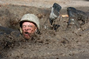 Seek Stress to Learn - Soldier crawling through deep mud
