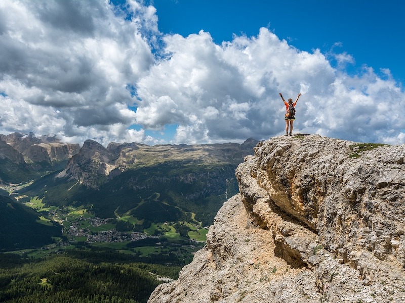 Person at top of mountain for personal development goals concept
