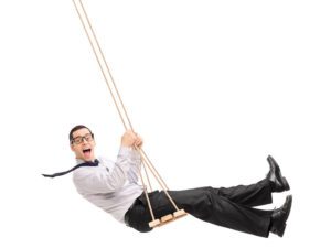 Business man on swing for importance of play for adults concept
