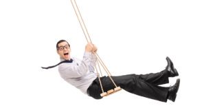 Businessman on swing with tie flying