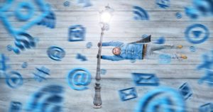 Man holding onto lampost horizontal in social media symbol storm for how to declutter digital life concept