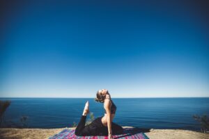 Woman doing yoga with ocean in background